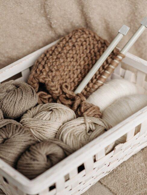 cagette remplie de pelotes de laines et d'aiguilles a tricoter